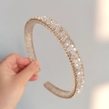 Detailed view of rhinestone headband with gold woven edges and hand-set crystals - White