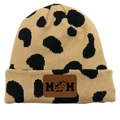 Detailed close-up of cow print knit beanie featuring a brown leather MOM logo patch - Dalmatian Khaki/Beige Cow
