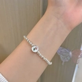 Silver bead bracelet with red flower enamel charm shown on wrist with butterfly decor - Silver Beaded Flower Enamel (MY30280)