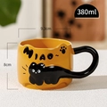 Yellow ceramic cat mug with embossed black cat design and tail handle 380ml capacity - Orange