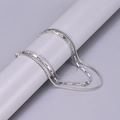 Detailed macro view of triple-layered silver stainless steel necklace on a gray display stand - Silver