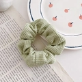 Pastelgroene scrunchie van wafelstof in bloemenstijl op een decoratieve achtergrond - 8# Matcha Groen