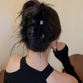 Detail of elegant black feather hair claw clip with rhinestones worn on a bun hairstyle - Black Heart Claw (Style 33)