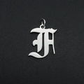 Macro shot of silver gothic letter H hollow pendant with metallic polished finish - Letter F