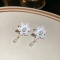 Détail de boucles d'oreilles flocon avec pompons roses et perles sur plat céramique - Boucles d'oreilles flocon de neige rose et blanc (Tige d'oreille en argent)