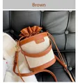 Detail of canvas bucket bag with brown leather trim, drawstring closure and metal hardware - Canvas Patchwork Bucket Bag (XQD21121) / Brown