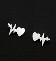 Minimalist silver heart heartbeat stud earrings for women on a dark background - Silver