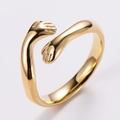 Macro di un anello a forma di mani che si abbracciano in oro lucido, design aperto - US 6 / Oro