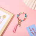 Colorful resin chain bracelet with pink tassel and golden ring on pink background - Colorful