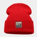 Detail of red ribbed knit beanie featuring vintage style denim supplies patch - M (56-58cm) / Red