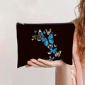 Detail of a black canvas makeup bag featuring a blue and gold butterfly print and metal zipper - Blue Gold Flying Butterflies (jiayingpbb0337)