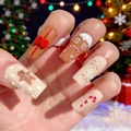 Macro shot of Christmas gingerbread 3D relief nail art with snowflake and candy cane designs - Gingerbread Man and House Relief Style (BW177)