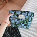 Detail of floral jacquard canvas makeup bag with blue flowers and TIME TO PARTY label - Black With Blue Flowers