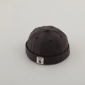 Dettaglio del berretto docker grigio scuro in cotone con etichetta S e bordo arrotolato - Etichetta Lettera S - Grigio Scuro