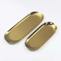 Primo piano di due vassoi ovali in acciaio inossidabile dorato lucido con finitura a specchio - Piccolo (18*8.5cm) / Oro
