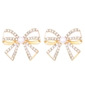 Detail of gold bow earrings with white enamel, pearl center, and sparkling rhinestones - White