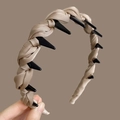 Detail of champagne silk braided headband featuring integrated black plastic hair clips - Khaki