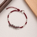 Detail of red braided cord bracelet with five silver-tone ancient coins on textured base - Red-Five Emperor Coins