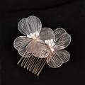 Primer plano de un elegante peine para el pelo floral en oro y plata con perlas en negro - KC Blanco