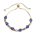 Detailed macro view of gold-plated Hamsa hand and blue enamel evil eye adjustable bracelet - Blue