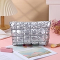 Silver quilted down-filled cosmetic bag in shiny finish placed on pink background - Clutch Bag / Silver