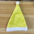 Classic yellow plush Santa hat with white fur trim and pom-pom on wooden background - Banana Yellow