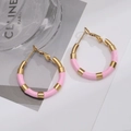 Detail of pink enamel and gold-plated titanium steel hoop earrings on stylish magazine - Pink