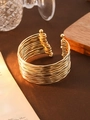 Macro detail of a wide multi-layer wavy golden cuff bracelet with round ball ends - 14 Waves / Gold
