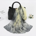 Détail d'une écharpe en mousseline fleurie drapée élégamment sur un sac à main noir - 150cm / Jaune Clair