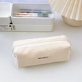 Close-up of minimalist cream corduroy pencil case with fabric label on aesthetic desk - Milk White