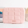 Pink quilted laptop sleeve with square stitching and leather logo on a cozy desk setup - 14" / Pink