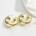 Macro detail of chunky gold C-shaped hoop earrings on elegant white textured surface - U-Shape Thickened