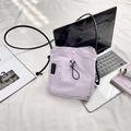 Close-up of light purple nylon crossbody bag with drawstring closure and brand label - Light Purple