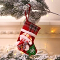 Close-up of a red fabric Christmas stocking with 3D snowman and sequined tree on pine branch - E-W02 Small Plaid Snowman Stocking