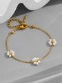 Dettaglio del bracciale dorato con fiori di perle bianche su sfondo ondulato - S538 Bracciale-Tre Fiori
