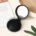 Foldable black round hairbrush with built-in mirror and compact travel air cushion design - Black