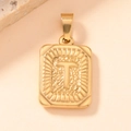 Macro detail of gold-plated square pendant with embossed letter T and hammered texture - Letter T