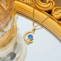 Collar de astronauta y luna dorada con el detalle de una esfera celestial azul brillante - Estilo Astronauta Sosteniendo la Luna (C505 Dorado)