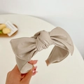 Macro detail of the beige faux leather texture and bow knot design on this headband - Leather Bow Headband / Beige