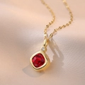Macro shot of square red gemstone pendant on a gold chain over champagne silk fabric - Gold Plated Stainless Steel + Zirconia / Red