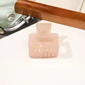 Detail view of a square pink pearlescent PVC hair claw clip on a white surface - PVC 5cm Square - Iridescent Orange