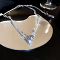 Detalle de un colgante de gato esfinge plateado con ojos de circón azul sobre espejo corazón - Aleación Plateada con Circonita / Collar Plateado (HN3128)
