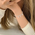 Macro detail of a silver smiley face charm bracelet on wrist for a minimalist style - Silver Hollow Smiley Face (MY31022)