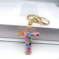 Detailed macro view of letter T resin keychain with colorful heart sequins and gold ring - Letter T Lobster Clasp Keychain