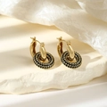 Detailed macro view of high-end golden hoop earrings with black zircon pavé setting - Black Zirconia