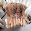 Sciarpa pashmina cammello con ricamo paisley e lunghe frange su una sedia - Cachi