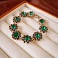 Dettaglio di bracciale vintage dorato con cristalli verdi e pietre nere in scatola - Bracciale-Verde