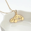 Minimalistische Gold-Edelstahlkette mit Cartoon-Käfer-Anhänger auf weißem Teller - Gold