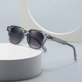 Retro narrow frame sunglasses in transparent grey on a minimalist geometric display stand - Transparent Gray Frame Gray Gradient Lens