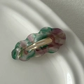 Close-up of wavy acetate hair clip with green marble texture and golden lettering - Pink & Green